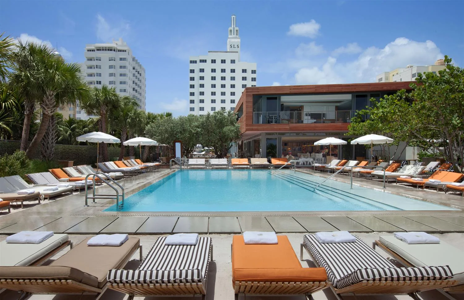 Hyde Beach’s outdoor pool and cabanas at SLS South Beach, with the hotel tower behind the pool deck